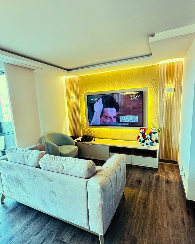 Sala con centro de entretenimiento iluminado en LED dorado